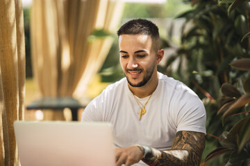 Wall Mural - Closeup of a young Caucasian guy working on his computer