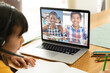 © vectorfusionart - Asian girl using laptop for video call, with smiling high elementary school pupils on screen