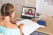 © vectorfusionart - Caucasian girl using laptop for video call, with elementary school pupil on screen