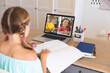 © vectorfusionart - Caucasian girl using laptop for video call, with diverse elementary school pupils on screen