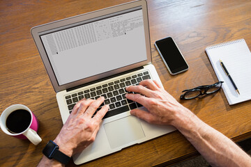 hands of caucasian male programmer siting at desk, using laptop with coding on screen