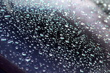 Abstract Turquoise And Purple Water Droplets On Slanted Glass After Rain