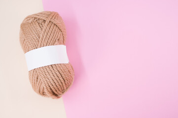 Canvas Print - Vertical shot of isolated soft beige yarn ball on an pastel pink background