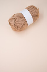 Canvas Print - Vertical shot of isolated soft beige yarn ball on an a coral background