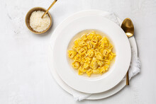 Tortellini. Pasta Stuffed With A Mix Of Meat, And Parmigiano Cheese And Served In Capon Broth. Top View, White Background.