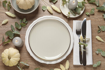 Sticker - Festive table setting with floral decor and pumpkins on wooden background, flat lay