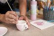 canvas print picture - Keramik malen, weiß und rosa, mit Pinsel und Frauenhand