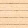 Concrete block wall painted with light peach-orange paint. Seamless pattern. Brickwall background.