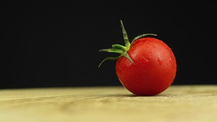 Wall Mural - Red cherry tomatoes rotate on a wooden board 