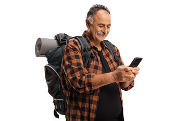 Poster - Mature male hiker with a backpack holding a mobile phone and typing