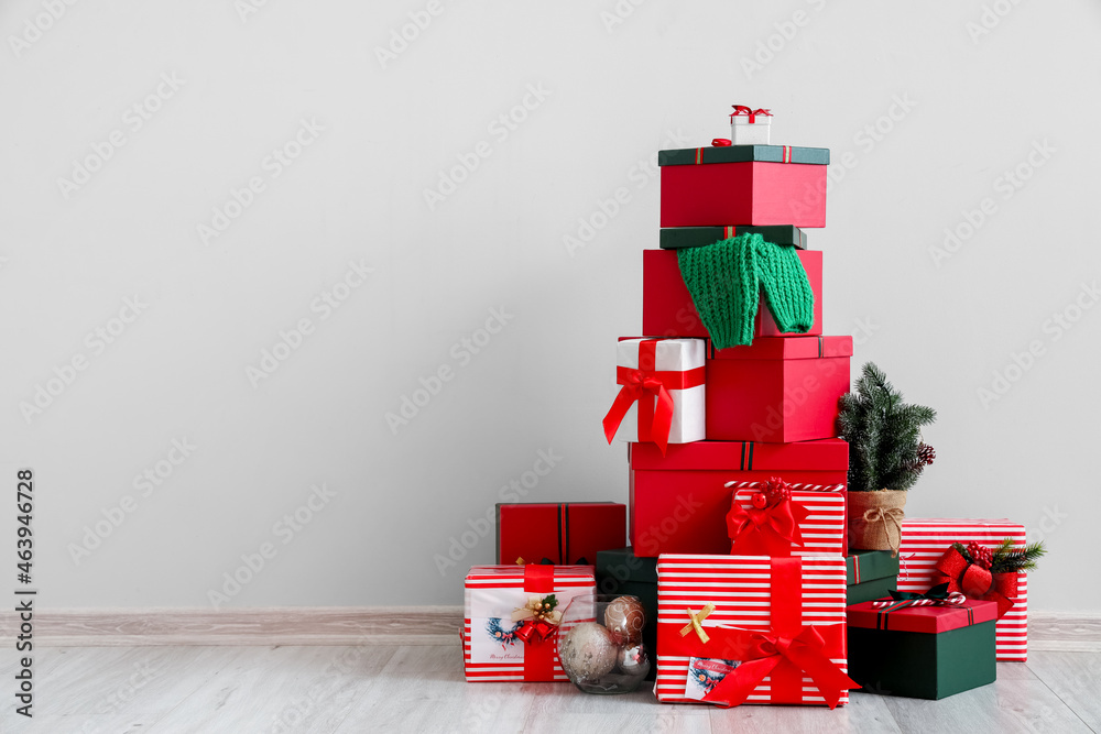 Beautiful Christmas gifts near light wall