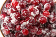 Bowl with tasty sugared cranberries on white background, closeup