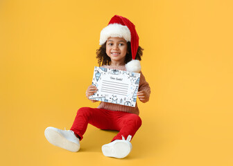 Sticker - Cute African-American girl with letter to Santa on color background