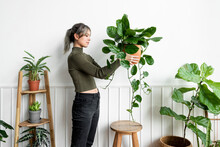 Happy Woman Carrying A Houseplant