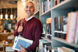 © Drazen - Portrait of happy mature student at university library looking at camera.
