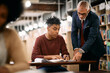 © Drazen - Mature teacher assisting his African American student with learning in a library.