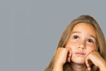 Wall Mural - Child little girl with a pensive expression on her face.