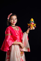 Wall Mural - Cute Indian little girl holding diya or oil lamps for Diwali Celebration.