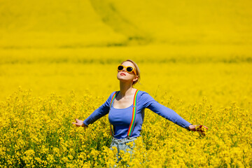 Sticker - Beautiful female in rainbow LGBT suspenders for pants in rapeseed field