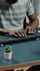 Poster - Close up of african american hands typing on computer keyboard for business remote work. Black person working from home with gadgets and technology at desk with notebook. Afro entrepreneur