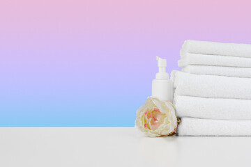 Wall Mural - Stacked clean towels on white table against color background