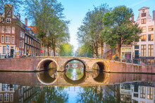 Amsterdam. Panoramic View Of The Historic City Center Of Amsterdam. Traditional Houses And Bridges Of Amsterdam. An Early Quiet Morning And The Serene Reflection Of Houses In The Water. 