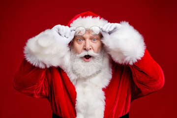 Sticker - Photo of amazed surprised retired man wear santa claus costume arms spectacles open mouth isolated red color background