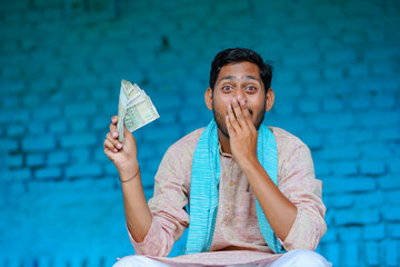 Wall Mural - Happy Indian farmer showing money at home.