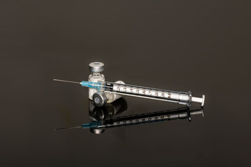 Syringe with vials and Needle on Gray background with copy  space