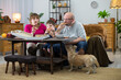 © fotodrobik - The family distributes slices of pizza to the whole family and the dog waits his turn.