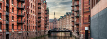 Panoramic View Of Canal And Historic Buildings In Old Warehouse District Speicherstadt In Hamburg, Germany