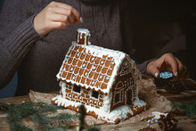 Female hands decorate the Christmas gingerbread house
