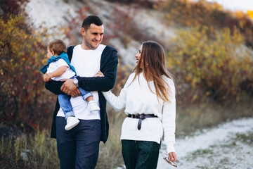 Wall Mural - Young family with little son walking in park