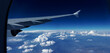 Wolkenpanorama mit A380 Flugzeugflügel vor blauschwarzem Horizont