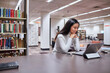 © Austockphoto - Young female Asian student working on her laptop at university library
