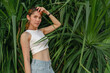© Sevendeman - Beautiful Asian woman pose on green palm bush for photography in summer concept.