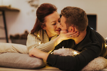 Man and woman lying on the floor in Christmas decorated home