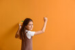Cute little girl painting on color wall