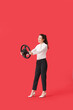 © Pixel-Shot - Young businesswoman with steering wheel on red background