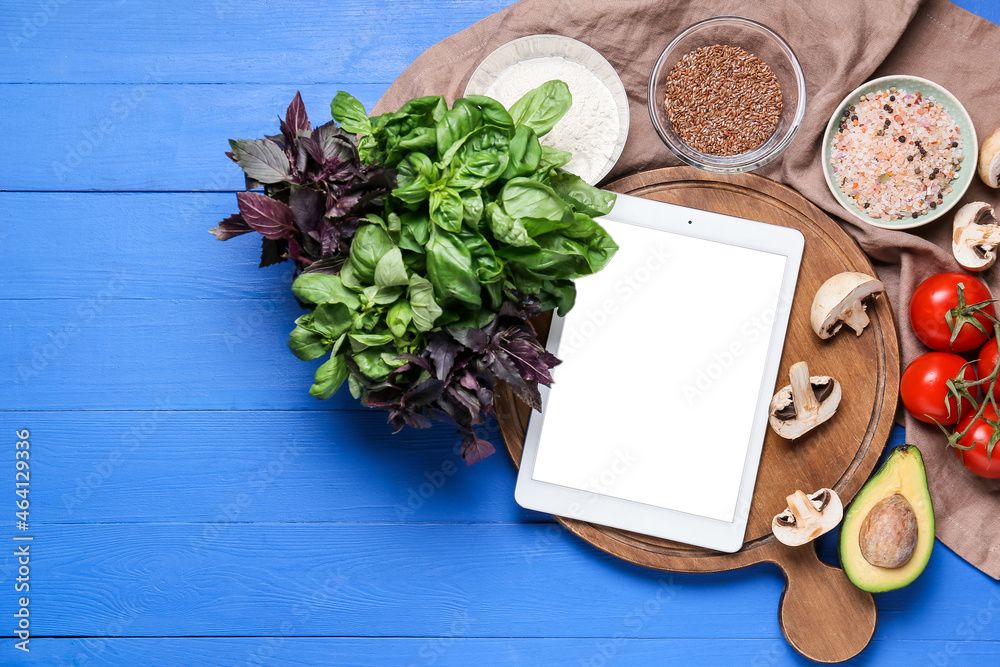 Digital recipe book and different ingredients on color wooden background