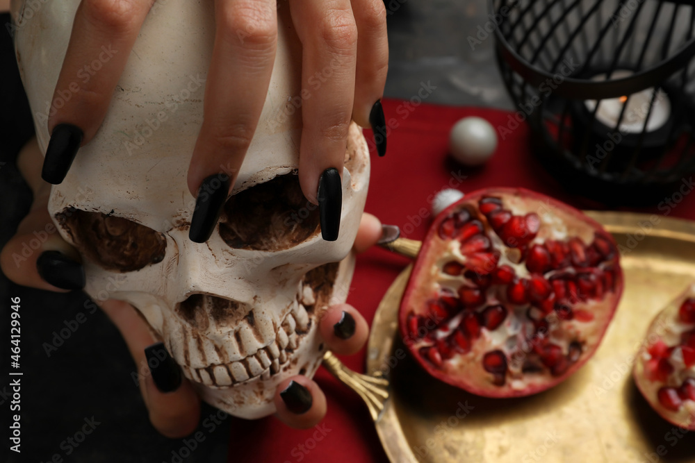Evil witch with skull at table, closeup