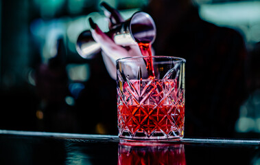 Wall Mural - woman hand bartender making negroni cocktail in bar