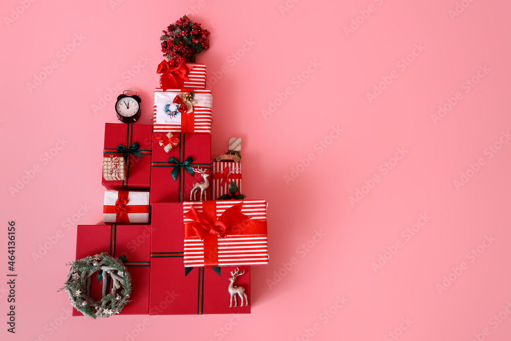 Christmas tree made of gift boxes and rowan on pink background