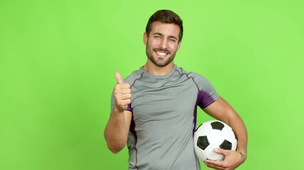 Wall Mural - Handsome man playing futbol and with thumb up over isolated background