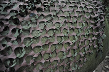Closeup Of A Camouflage Net Covering A Rock