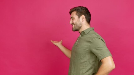 Wall Mural - Handsome man pointing back and presenting a product over isolated background