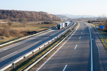 Caravan or convoy of trucks in line on a country highway.