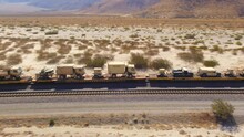 United States Army Train Transporting Military Vehicles Through The Desert, Aerial Tracking Shot As The Train Passes