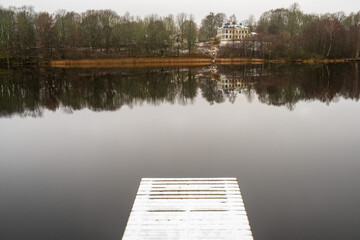 Lake with a mansion on a hill and water reflection