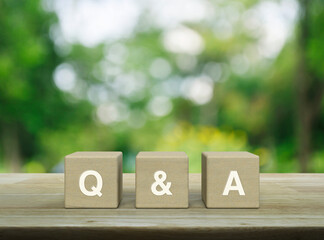 Poster - Q and A acronym on wood block cubes on wooden table over blur green tree in park, Frequently asked questions, Business customer service and support concept